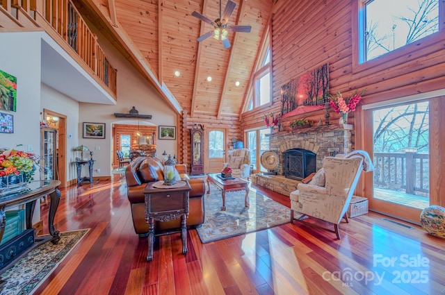 living room featuring rustic walls, wood ceiling, and high vaulted ceiling