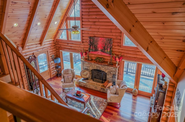 living room featuring rustic walls, beam ceiling, light hardwood / wood-style floors, and wooden ceiling