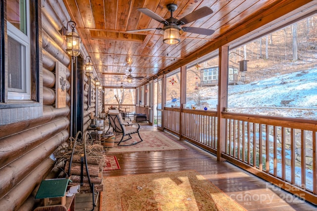 unfurnished sunroom featuring ceiling fan, wood ceiling, and vaulted ceiling