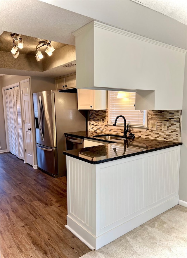 kitchen featuring backsplash, sink, a textured ceiling, white cabinetry, and stainless steel appliances