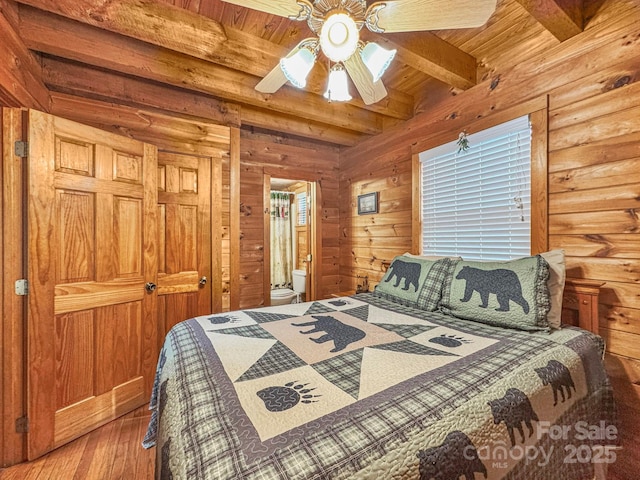 bedroom with ensuite bath, wood-type flooring, ceiling fan, wooden ceiling, and beam ceiling