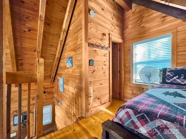 bedroom featuring wood walls, hardwood / wood-style floors, vaulted ceiling with beams, and wooden ceiling