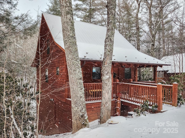 snow covered property featuring a porch