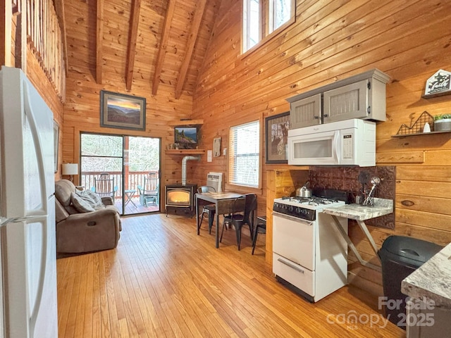 kitchen featuring beamed ceiling, white appliances, wooden ceiling, a wood stove, and high vaulted ceiling