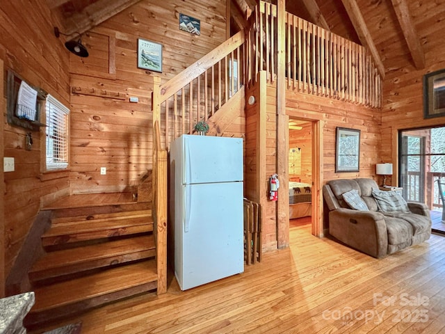 kitchen featuring wooden ceiling, beamed ceiling, wood walls, and white fridge