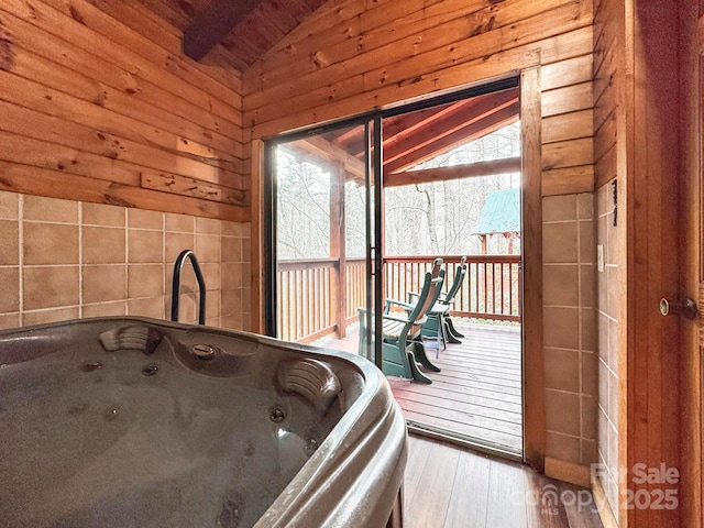 bathroom with wood walls, wood-type flooring, and lofted ceiling