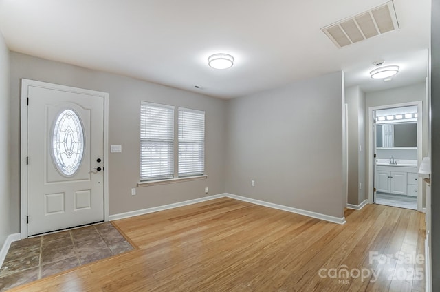 foyer entrance featuring light wood-type flooring and sink