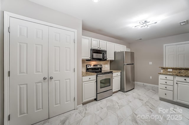 kitchen featuring light stone countertops, decorative backsplash, white cabinetry, and stainless steel appliances