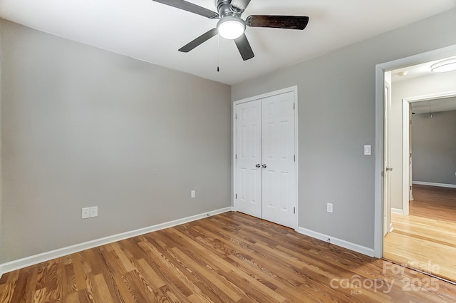 unfurnished bedroom featuring a closet, hardwood / wood-style flooring, and ceiling fan