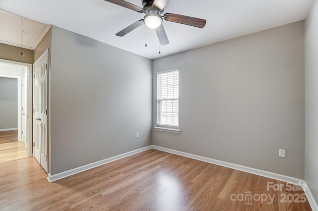 empty room with ceiling fan and light hardwood / wood-style floors