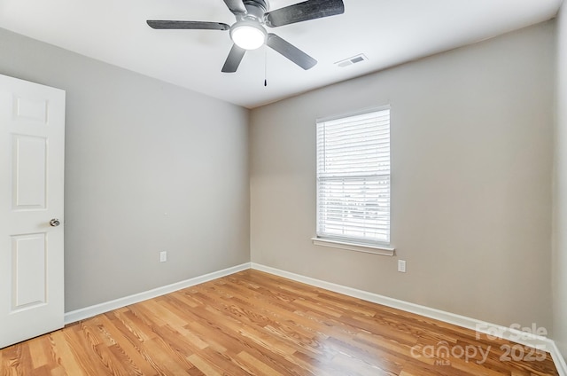 empty room featuring ceiling fan, hardwood / wood-style floors, and a healthy amount of sunlight