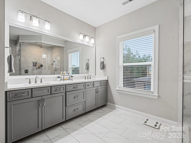 bathroom featuring vanity, a wealth of natural light, and a shower with shower door