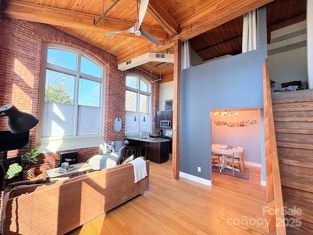 office featuring beamed ceiling, light hardwood / wood-style floors, ceiling fan, and wooden ceiling