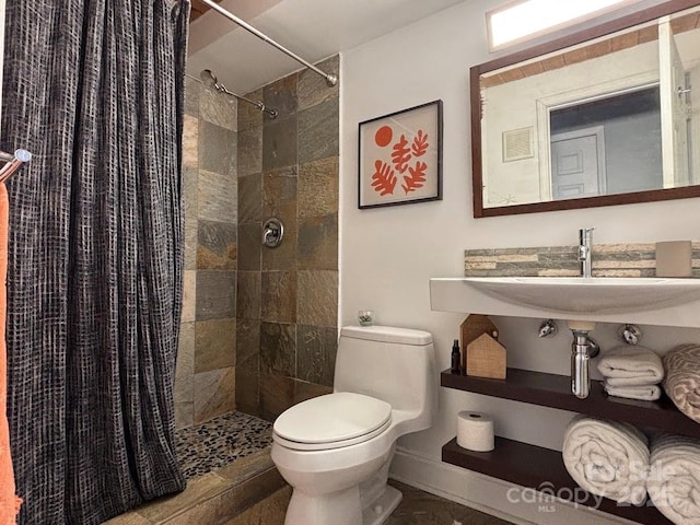 bathroom with curtained shower, sink, and toilet