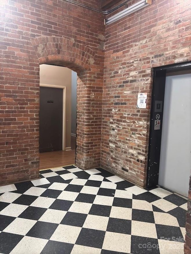 interior space featuring elevator and brick wall