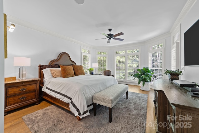 bedroom with ceiling fan, crown molding, and light hardwood / wood-style floors