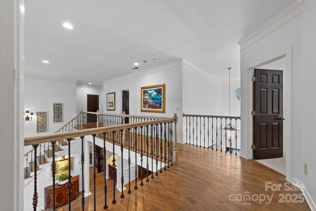 corridor featuring wood-type flooring and crown molding