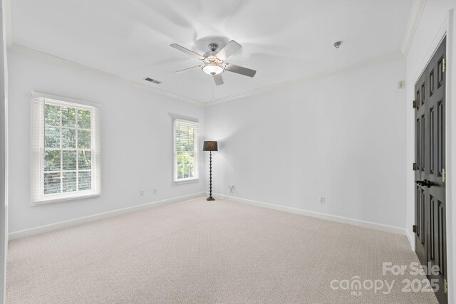 carpeted spare room featuring ceiling fan and ornamental molding