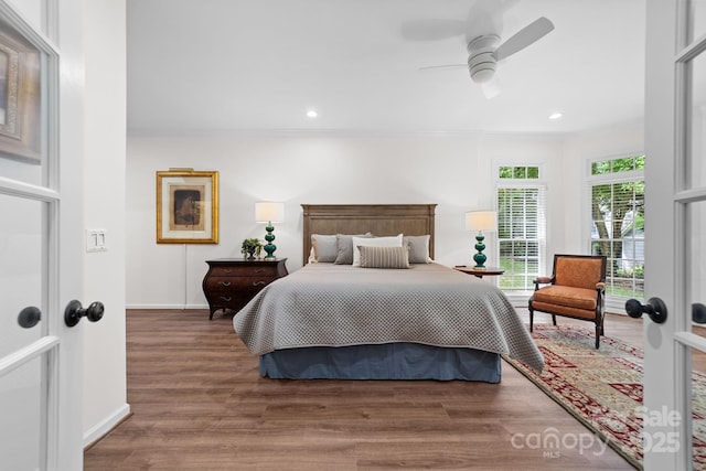 bedroom with french doors, hardwood / wood-style flooring, ceiling fan, and ornamental molding