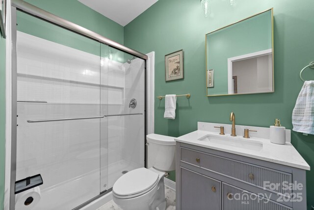 bathroom featuring vanity, an enclosed shower, and toilet