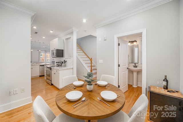 dining area featuring ornamental molding and light hardwood / wood-style flooring