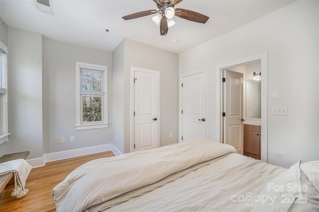 bedroom featuring ceiling fan, light hardwood / wood-style floors, and ensuite bath