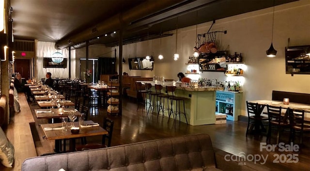 bar with decorative light fixtures and wood-type flooring