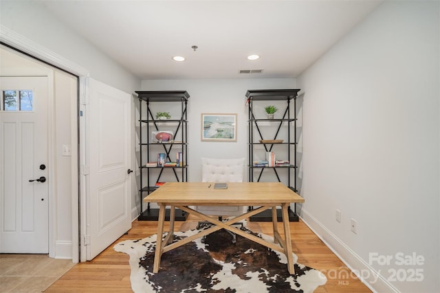 home office with light hardwood / wood-style floors