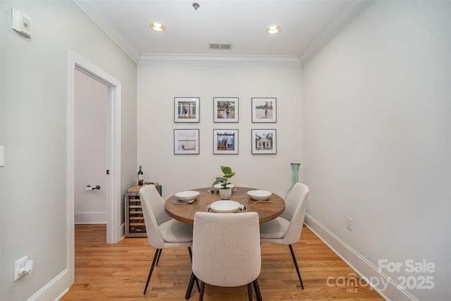 dining space featuring light hardwood / wood-style flooring and ornamental molding