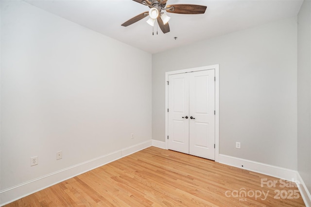 unfurnished bedroom with ceiling fan, a closet, and hardwood / wood-style floors