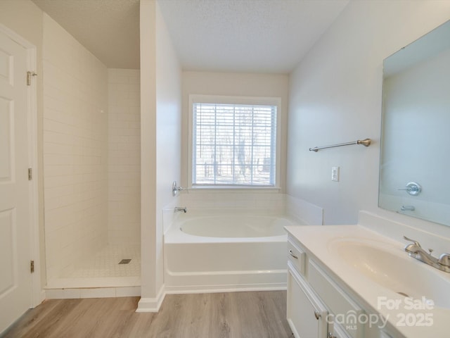 bathroom featuring vanity, hardwood / wood-style flooring, a textured ceiling, and separate shower and tub