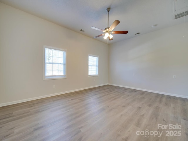 unfurnished room with ceiling fan, lofted ceiling, and light wood-type flooring