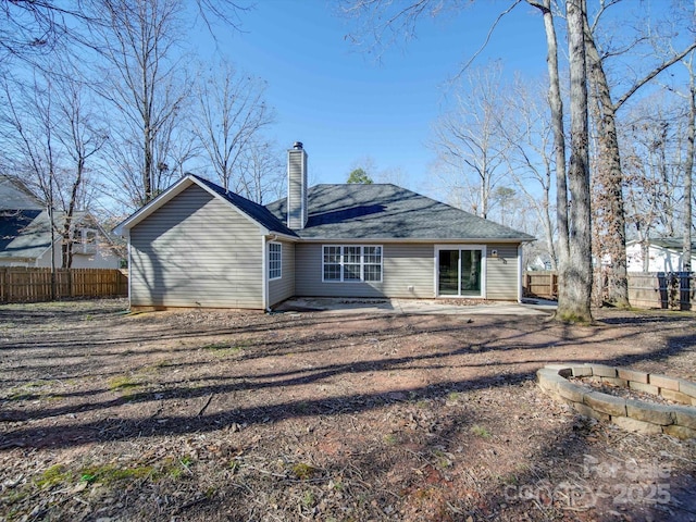 rear view of property with a patio and an outdoor fire pit