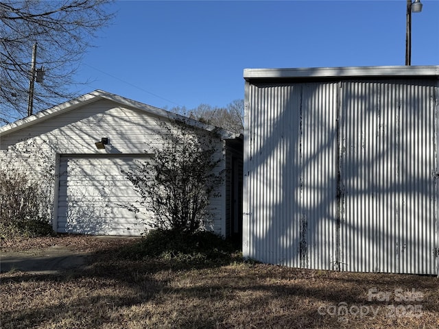 view of property exterior featuring a garage and an outdoor structure