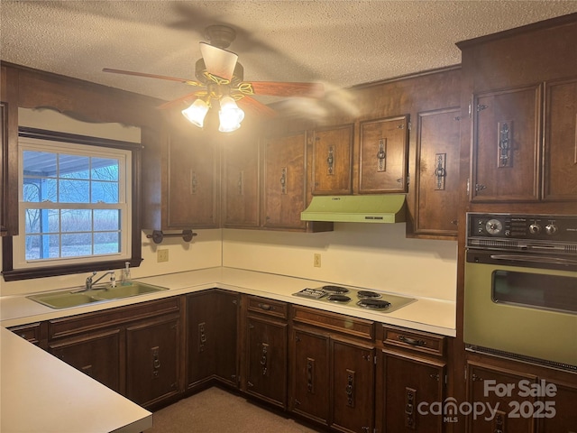 kitchen with wall oven, sink, white cooktop, and a textured ceiling