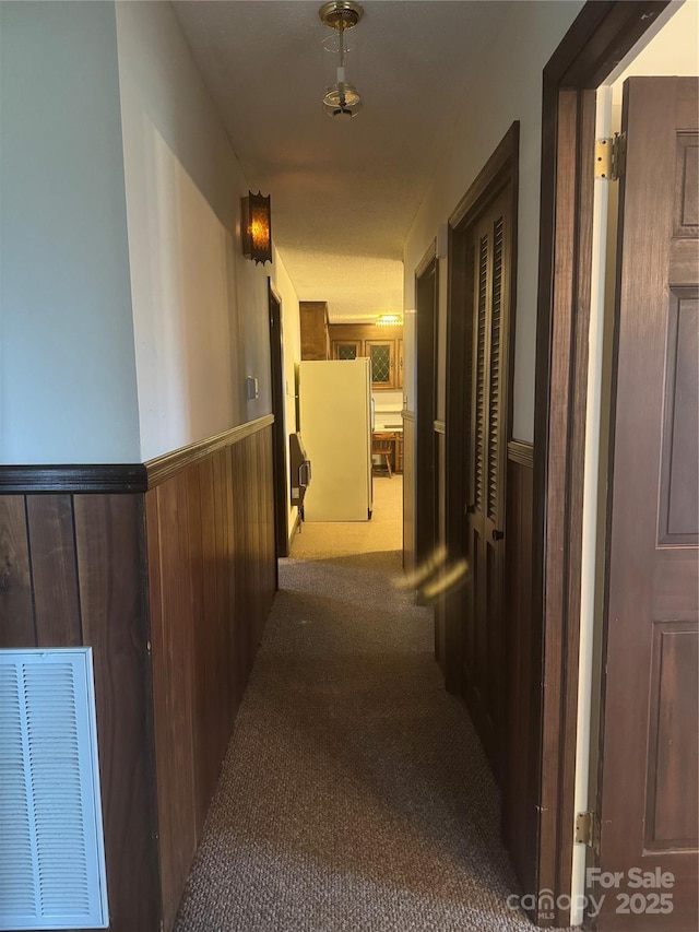 corridor with carpet and wood walls