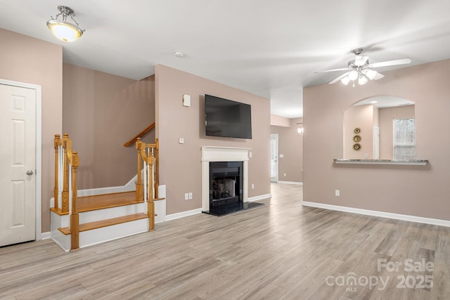 unfurnished living room featuring ceiling fan and light hardwood / wood-style floors