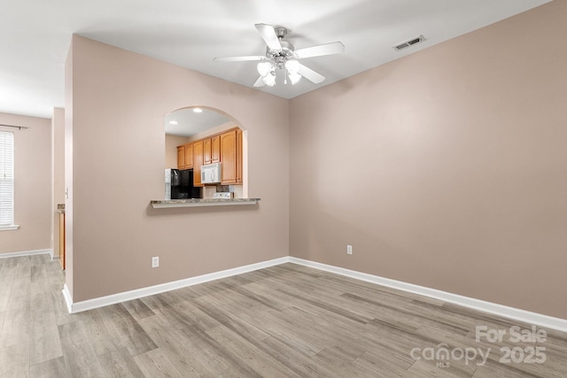 empty room featuring ceiling fan and light hardwood / wood-style floors