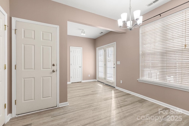 entrance foyer featuring a notable chandelier and light hardwood / wood-style floors