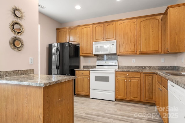 kitchen with white appliances, light hardwood / wood-style flooring, and sink