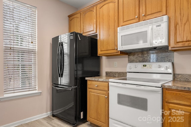 kitchen with white appliances and light wood-type flooring