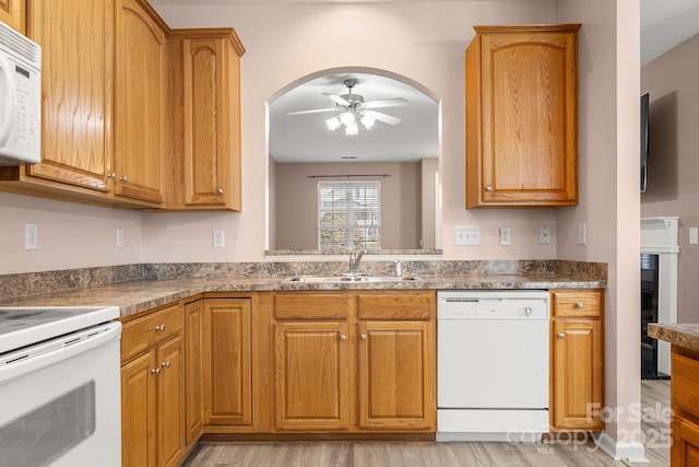 kitchen featuring ceiling fan, light wood-type flooring, white appliances, and sink