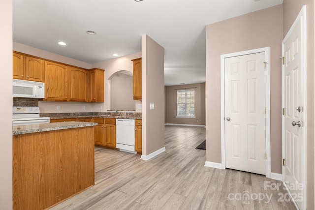 kitchen with white appliances, sink, and light hardwood / wood-style flooring