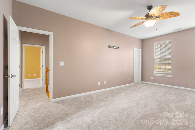 carpeted spare room featuring ceiling fan