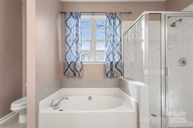 bathroom featuring tile patterned flooring, shower with separate bathtub, toilet, and a wealth of natural light