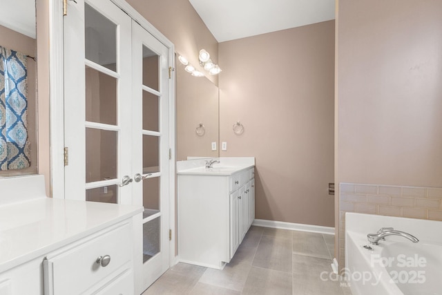 bathroom featuring tile patterned floors, vanity, and a bath