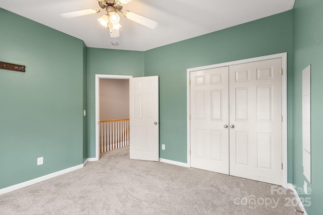 unfurnished bedroom featuring ceiling fan, a closet, and light colored carpet