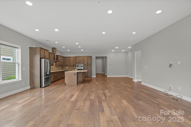 253 Stone Mountain Way, Denver, NC 28037 - kitchen with stainless steel appliances, open floor plan, light wood-style floors, recessed lighting, and an island with sink