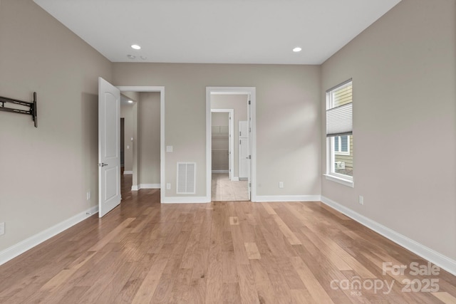 253 Stone Mountain Way, Denver, NC 28037 - unfurnished bedroom featuring light wood-style flooring, a walk in closet, baseboards, and recessed lighting