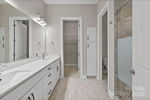 253 Stone Mountain Way, Denver, NC 28037 - bathroom featuring double vanity, marble finish floors, a stall shower, toilet, and a spacious closet